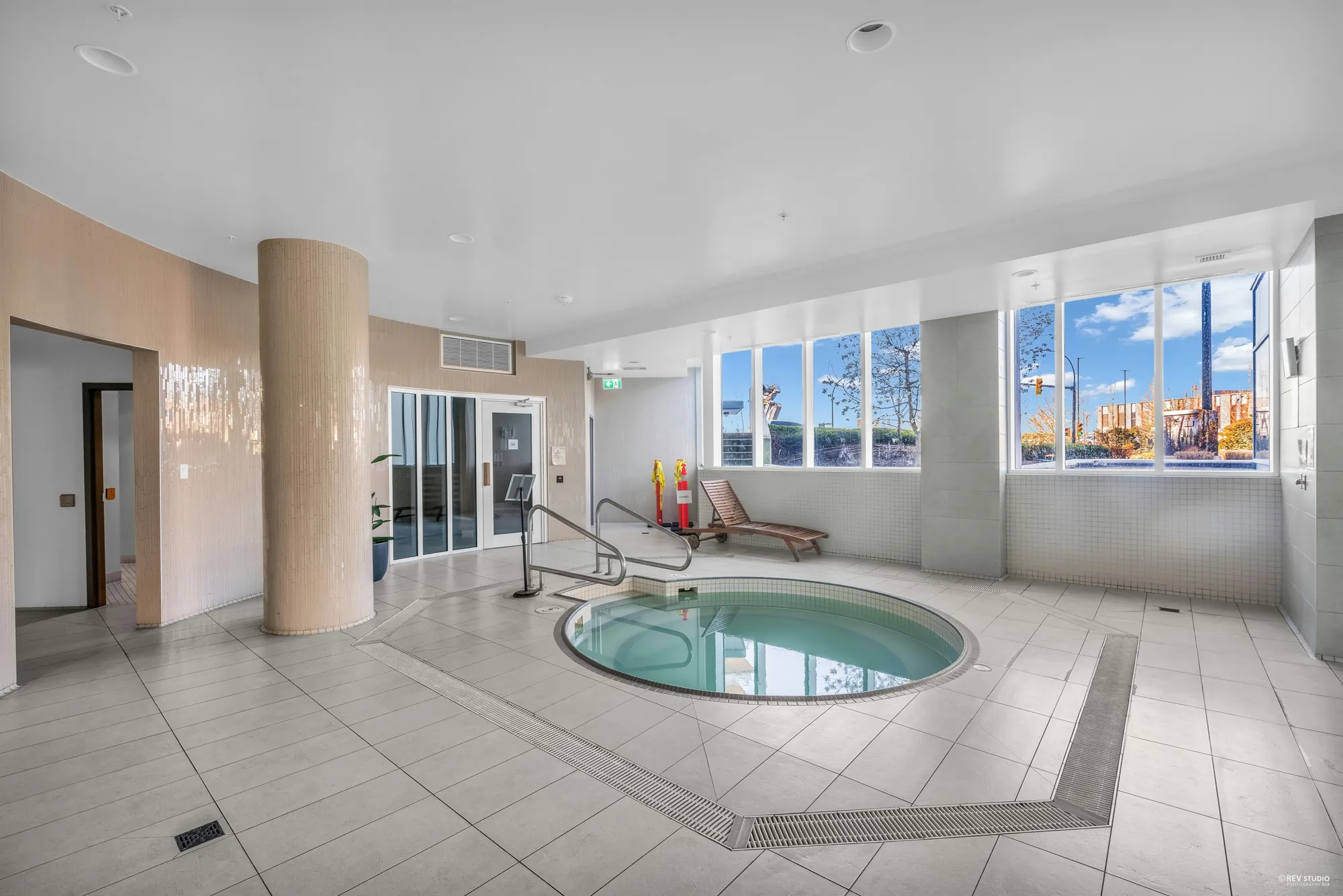 The hot tub in a tiled room with windows