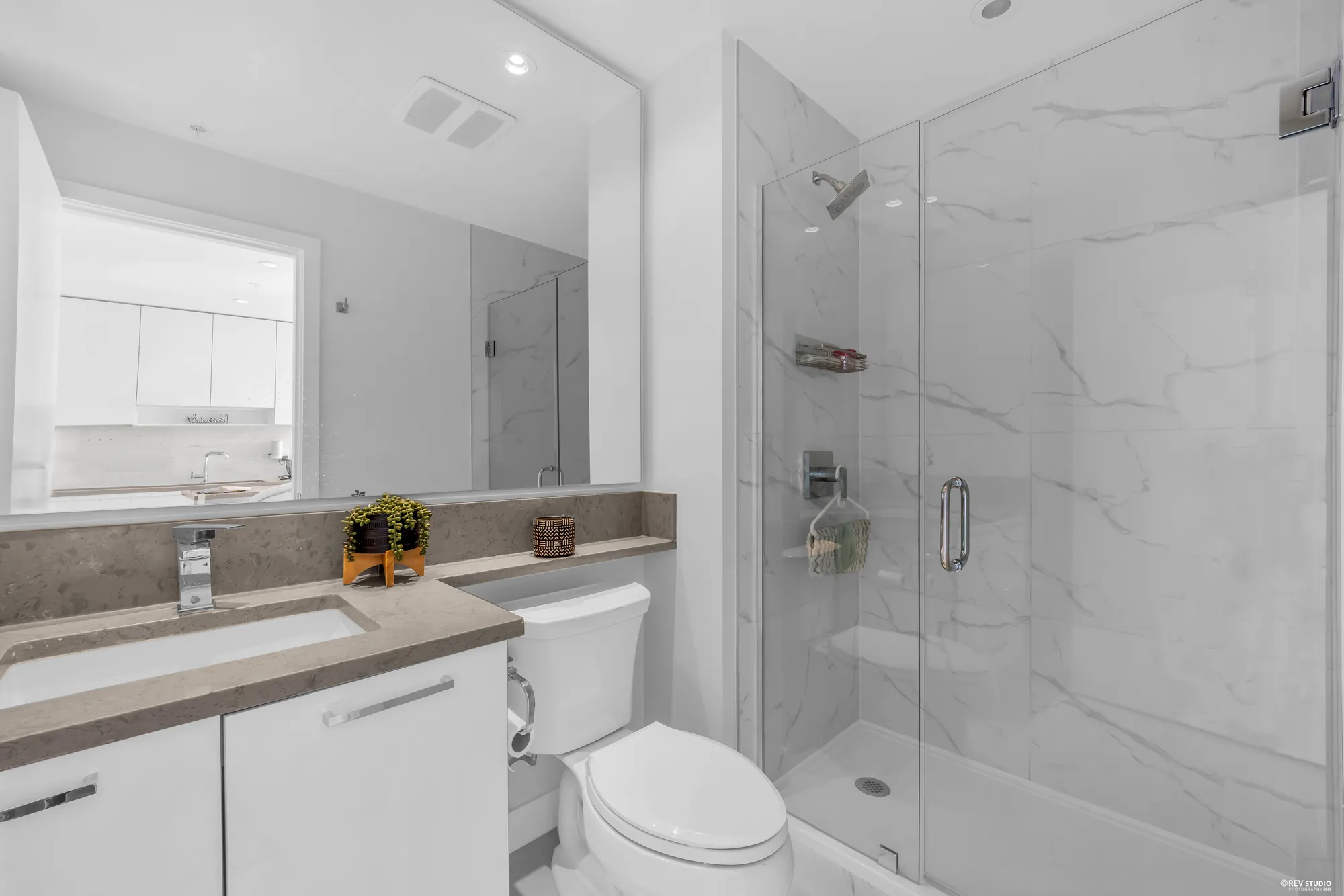 The ensuite with a walk-in shower, a long vanity and a window