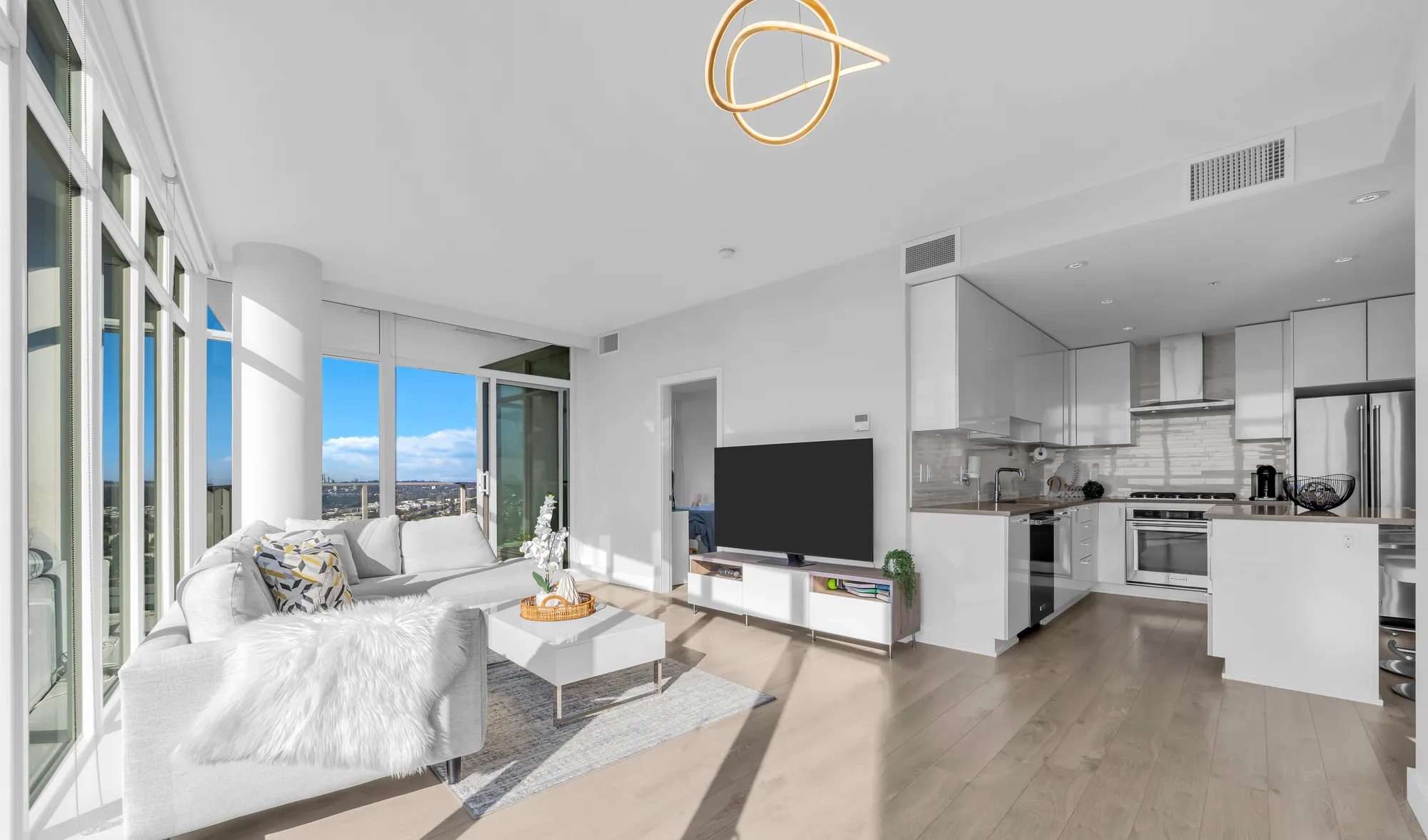 The living room of 3802 with glass on two walls, looking west over Burnaby