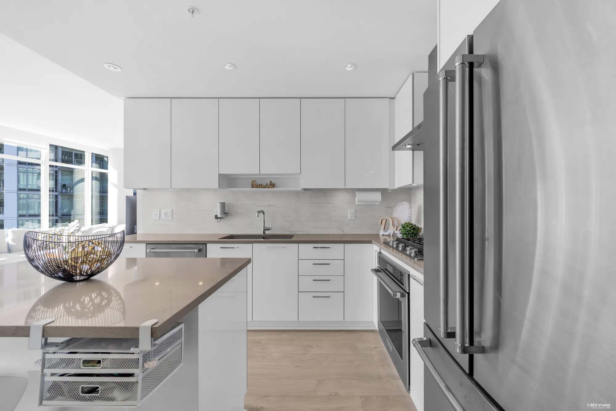 The kitchen counter run with the wall oven and the stainless refrigerator