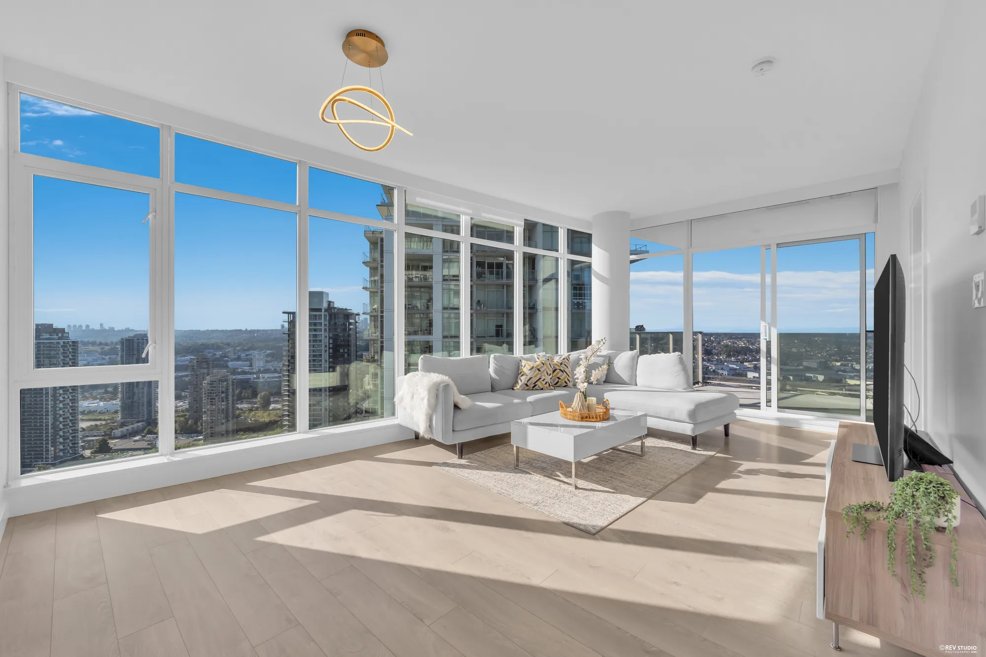 The living room with glass on two walls and the dining area beyond