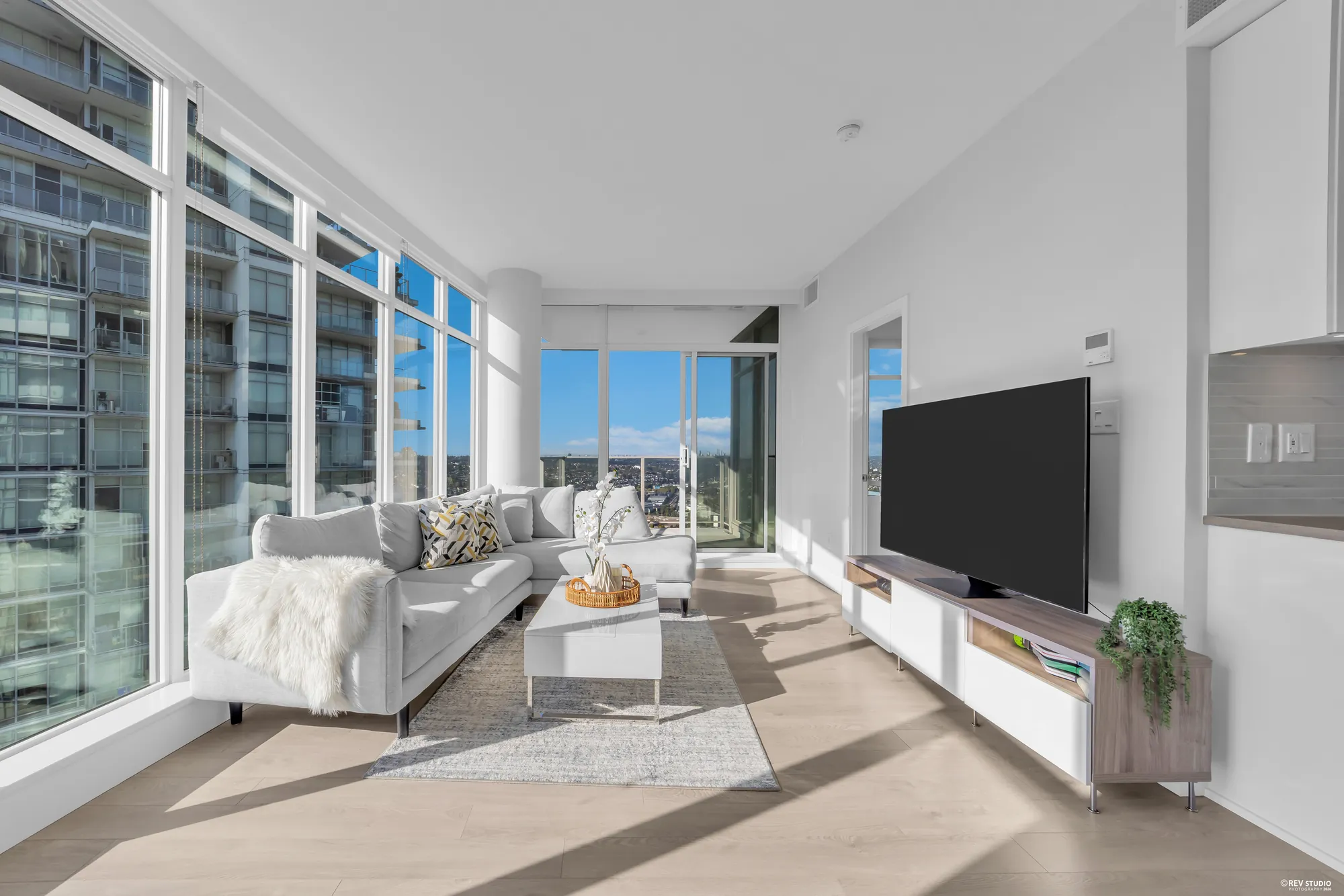 The living room from the dining end, with the television wall and the balcony doors