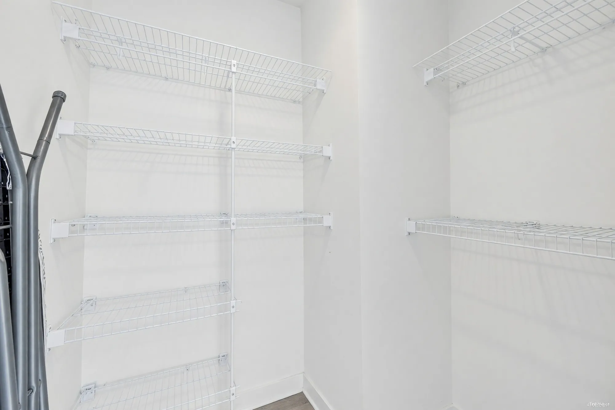 The walk-in closet fitted with wire shelving, photographed after its contents were digitally removed